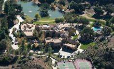 an aerial view of a tennis court and mansion