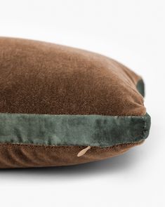 a brown and green pillow sitting on top of a white table