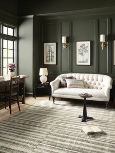 a living room with green walls and furniture in the corner, including a white couch