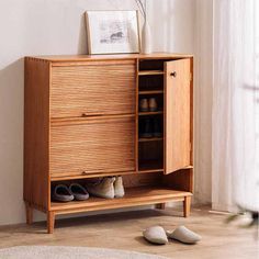 a wooden cabinet with shoes underneath it