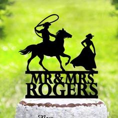 a cake topper with the silhouette of a man and woman riding horses on it