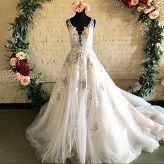 a wedding dress on display with flowers around it