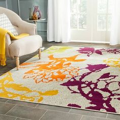 an area rug with various colors and designs on it in front of a white chair