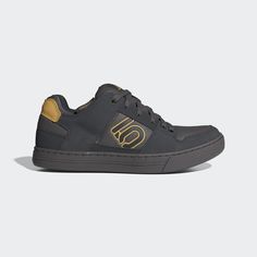 a black and gold sneaker with the letter s on it's upper part