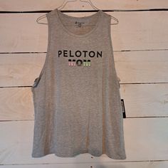 This Peloton Mom Tank Top Shirt In Size 2xl Is Perfect For Any Athletic Activity, Such As Cycling Or Crossfit. The Sleeveless Design And Pullover Style Make It Comfortable And Easy To Wear, While The Gray Color Adds A Touch Of Style To Your Activewear. The Tank Top Is Made By Peloton, A Well-Known Brand In The Fitness Industry, And Is Designed To Fit Athletically. The Shirt Is Ideal For Plus-Sized Women And Comes With Tags, Making It A Great Gift For Yourself Or A Friend. It Is Perfect For Any O Compressive Tank Top For Pilates, Sweat-resistant Medium Support Tank Top For Workout, Peloton Apparel, 4-way Stretch Tank Top For Pilates, Tank T-shirt With Letter Print For Workout, Mom Tank Tops, Muscle Tanks, Tank Top Shirt, Pullover Styling