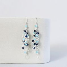 These beautiful and lightweight drop earrings combine wire-wrapped loops with iolite and blue apatite gemstones for a perfect blue and silver color combination that will compliment any silver jewelry in your collection.Silver drop earrings with real gemstones. 100% handmade in the USA in our New York City studio.Earrings are made of .925 sterling silver and have french hooks. (Safety backs are included so you never to worry about them falling off).All of our earrings are meant to be worn with al Blue Teardrop Wire Wrapped Crystal Earrings, Blue Wire Wrapped Drop Earrings, Blue Wire Wrapped Dangle Earrings, Blue Wire Wrapped Dangle Crystal Earrings, Blue Sterling Silver Chandelier Earrings With Ear Wire, Blue Wire Wrapped Chandelier Earrings, Blue Wire Wrapped Dangle Chandelier Earrings, Blue Teardrop Wire Wrapped Chandelier Earrings, Blue Long Drop Wire Wrapped Jewelry