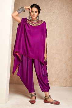 Purple embroidered triangle cut cape with a scallop trimmed round neckline and asymmetric hem. Paired with a dhoti pant.
Components: 2
Pattern: Embroidered
Type Of Work: Thread
Neckline: Round
Sleeve Type: Asymmetric
Fabric: Silk, Modal Satin
Color: Purple
Other Details: 
Weight: Approx 1000 gms
Length:
Cape Center Front: 25 inches
Pant: 28 inches
Model height: 5 ft. 7 inches, wearing size S
Occasion: Mehendi and Haldi - Aza Fashions Eid Sets With Dupatta And Cape Sleeves, Eid Palazzo Set With Dupatta And Cape Sleeves, Bollywood Style Designer Cape Sets, Bollywood Style Festive Sets With Cape, Festive Bollywood Sets With Cape, Festive Bollywood Cape Sets, Festive Palazzo Set With Cape Sleeves For Navratri, Anarkali Cape Set For Eid, Anarkali Set With Cape For Eid