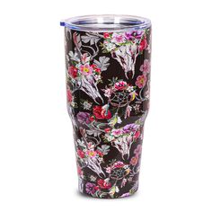 the tumbler is decorated with colorful flowers and birds on black, while it sits in front of a white background