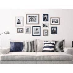 a living room filled with furniture and framed pictures on the wall above it's couch