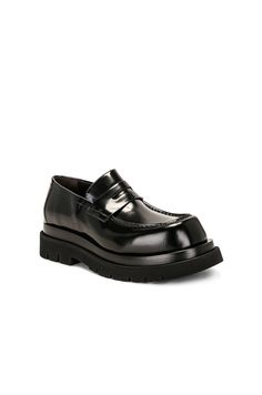 Find BOTTEGA VENETA Lug Loafer Gloss Vinyl on Editorialist. Bottega Veneta Lug Loafer Gloss Vinyl in Black Calfskin leather upper with lug rubber sole. Made in Italy. Penny strap at vamp. Glossy finish. Round toe. Approx 40mm/ 1.5 inch platform Approx 25mm/ 1 inch heel. BOTT-MZ98. 730222-V28R0-1000. About the designer: Bottega Veneta – inspiring individuality with innovative craftmanship since 1966. Creativity lies at the heart of all that we do. Born in Vicenza the house is rooted in Italian culture yet maintains a truly global outlook. An inclusive brand with exclusive products Bottega Veneta is as much of a feeling as it is an aesthetic. Black Calf Leather Loafers For Fall, Designer Leather Platform Loafers For Work, Designer Leather Loafers For Fall, Designer Fall Loafers For Workwear, Black Calf Leather Platform Loafers For Work, Black Calf Leather Loafers For Spring, Designer Leather Sole Loafers For Fall, Designer Fall Loafers With Leather Sole, Designer Black Platform Loafers For Work