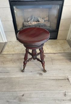 a small wooden table sitting in front of a fire place