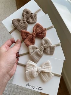 four little bow hair clips in various colors and sizes on top of a white card