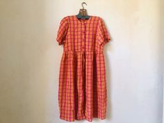 This vintage 90's plaid summer dress in orange and pink will be perfect for mischievous and carefree summer days! Your kid will radiate happiness as bright as the sun whenever they slip it on. - 85% viscose, 15% acetate - Lightweight and airy  - Full front-button closure - Short sleeves CONDITION. Very good vintage condition; the upper button is slightly different than the rest but it's not particularly noticeable.  SIZE. Marked size 140. Fits approximately 10 - 12 years old. To be sure it will Orange Pink Dress, Radiate Happiness, Plaid Summer Dress, Long Summer Dress, Vintage Kids Clothes, Airy Dress, Orange Plaid, Vintage Kids, Orange And Pink