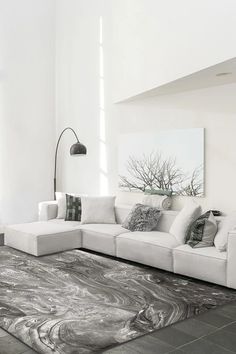 a living room with a large sectional couch in the center and an area rug on the floor