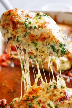 a piece of chicken parmesan being lifted from a casserole dish