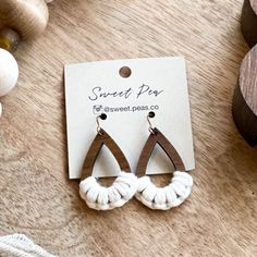 the earrings are made from wood and white yarn