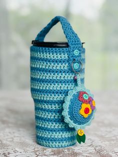 a crocheted blue purse with a flower on it