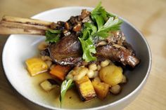 a white bowl filled with meat and vegetables