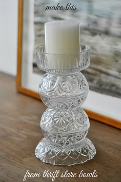 a clear glass candle holder sitting on top of a wooden table