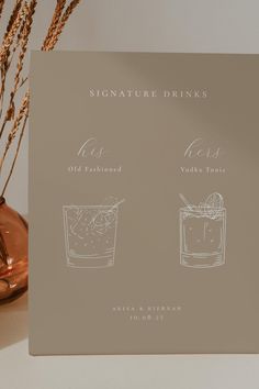 the menu for signature drinks is displayed next to a vase with dry grass in it