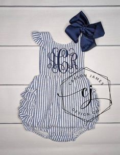 Check out this adorable monogrammed sunsuit! The perfect outfit to keep your little one cool yet stylish in those hot summer months!  This sunsuit is navy and white seersucker with ruffle trim. Made from 100% cotton. It is fully lined (not see through) with snaps at the crotch and criss cross straps that button in the back.  It also has elastic in the leg openings. A large monogram is embroidered directly onto the sunsuit using thread. Navy thread will be used unless otherwise noted in notes to Vacation Cotton Bubble Romper With Ruffles, Cotton Bubble Romper With Ruffles For Vacation, Fitted Cotton Bubble Romper For The Beach, Fitted Cotton Bubble Romper For Beach, Fitted Bubble Romper With Ruffles For Summer, Summer Fitted Bubble Romper With Ruffles, Fitted Ruffle Bubble Romper For Summer, Fitted Summer Bubble Romper With Ruffles