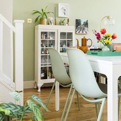 a dining room table with chairs and vases on it