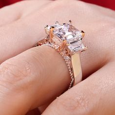 Luxurious and breathtaking, this engagement ring honors the light of your life. Crafted in two tone sterling silver, the ring features an emerald-cut center stone accented with two taper baguette-cut stones on a high polished shank. The shank is buffed to show a bright shine and elegant look. The delicate rose gold tone filigree details on the side of the ring adds elegance and vintage aesthetics to it. Surprised her with this masterpiece!Carat Weight: 3.85 ctStone Size: 7*9 mmStone Type: Jeulia Emerald Cut Baguette Diamond Promise Jewelry, Square Cut Emerald Ring With Accent Stones For Wedding, Emerald Asscher Cut Ring With Baguette Diamonds For Wedding, Silver Wedding Ring With Asscher Cut Accent Stones, Silver Radiant Cut Wedding Ring With Accent Stones, Silver Promise Ring With Baguette Diamonds, Emerald Cut Rose Gold Wedding Ring With Diamond Accents, Vintage Aesthetics, Baguette Cut