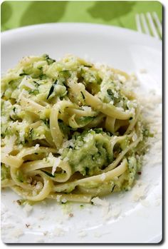 a white plate topped with pasta and broccoli