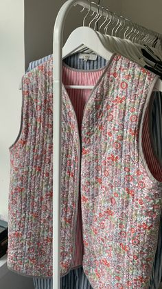 a vest hanging on a clothes rack in a closet