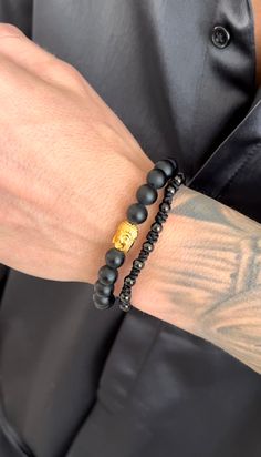 This Golden Buddha bracelet set is an adjustable beaded bracelet that shines with spiritual and cultural meaning. This "Awakened One" eight inch bracelet set is perfect for men and women's everyday wear to add some fresh detail to your wrist. (2 pc set) Great Holiday Gift Material: 18K Gold Plated on Stainless Steel. Tarnish and water resistant. ﻿ALL SALE ITEMS ARE FINAL SALE Adjustable Symbolic Gold Beaded Bracelets, Adjustable Hand Wrapped Spiritual Bracelet, Symbolic Adjustable Bracelet With 108 Beads, Adjustable Wrap Bracelet With 108 Beads For Meditation, Traditional Adjustable Black Bracelets, Spiritual Bangle Bracelet With 8mm Beads, Traditional Black Adjustable Beaded Bracelets, Traditional Black Adjustable Bracelets, Traditional Black Adjustable Bracelet