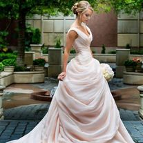 a woman in a wedding dress is walking down the street with her hand on her hip