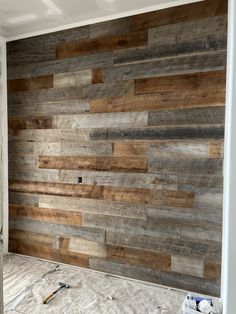 an unfinished room with wood paneling on the wall