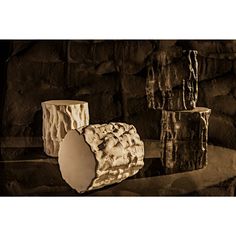 three vases sitting on top of a table next to each other in front of a stone wall