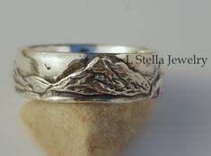 Mountain Band- Teton Mountain / Horse in Wedding Band / Mountain range with beautiful detailed Grand Tetons as the main feature in this landscape rustic wedding band. This peak soars 13,770 ft. above sea level and is spectacular!  A mountain landscape with a sunrise and horse or no animal.  Fantastic ring for the Hiker, outdoor mountain lover.   This listing is for the band only.  I meticulously carve this design in wax to capture the details and then cast it in solid sterling silver.  The photo Adjustable Etched Wedding Bands, Wedding Adjustable Etched Bands, Wedding Bands With Etched Detail And Adjustable Fit, Artisan Etched Jewelry For Wedding, Rustic Silver Wedding Rings, Rustic Silver Jewelry For Anniversary, Rustic Silver Jewelry For Wedding, Rustic Handmade Wedding Jewelry, Engraved Thick Wedding Bands