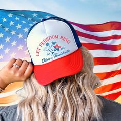 a woman with long blonde hair wearing a red, white and blue hat in front of an american flag