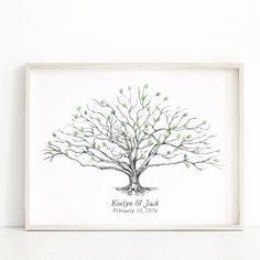 a wedding guest tree with green leaves on the branches is displayed in a white frame