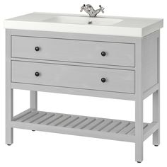 a gray dresser with two drawers and a shelf on the bottom that is holding an infant's crib