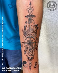 a person with a tattoo on their arm that has an image of a compass and other things