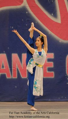 a woman in blue and white dancing on stage