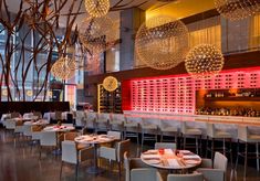 a restaurant with tables, chairs and chandeliers hanging from the ceiling