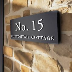 there is a sign that says no 15 cottontail cottage on the side of a brick wall