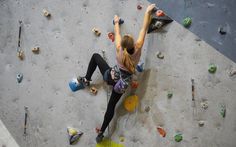 a woman climbing up the side of a rock wall