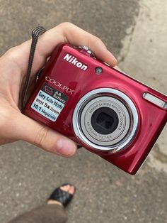 a person holding a red camera in their hand