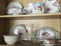 a shelf filled with china and dishes on top of wooden shelves