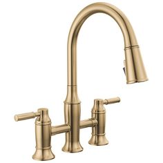 a brass colored kitchen faucet with two handles