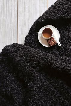 a cup of coffee on top of a black blanket