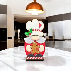 a santa clause cookie on top of a counter in a kitchen with lights above it