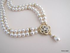 "This romantic double strand necklace has a victorian style rose pendant with clear stones set on an antique gold filigree. I have used Swarovski pearls in ivory/cream. All the Swarovski crystals in the pendant are handset by me. Pearls measure 8 mm in both strands accented with rhinestone beads. Rhinestone pendant is just under 1\" in diameter. Necklace is 17\" long inner strand. Finished off with antique gold finish filigree clasp adorned with Swarovski crystals. It comes with a 2\" extender c Classic Gold Bridal Necklace For Wedding, Double Strand Pearl Drop Jewelry For Wedding, Double Strand Gold Wedding Jewelry, Gold Double Strand Wedding Jewelry, Delicate Double Strand Necklace For Wedding, Double Strand Gold Jewelry For Wedding, Gold Double Strand Necklace For Wedding, Gold Pearl Embellished Necklaces For Wedding, Gold Pearl Chain Necklace For Mother Of The Bride