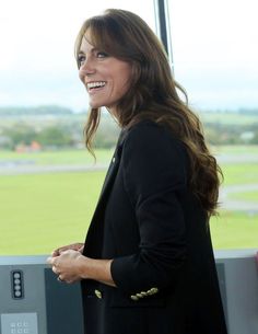 a woman standing in front of a window smiling