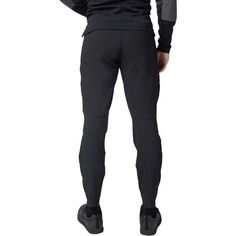 the back view of a man in black sweatpants with his hands on his hips